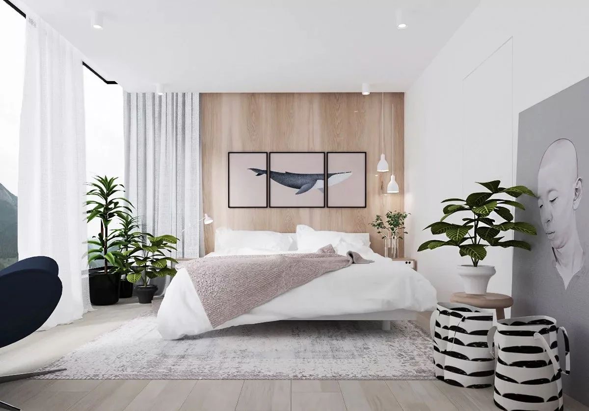 A bright, modern bedroom with a neatly made bed, plants, and contemporary artwork